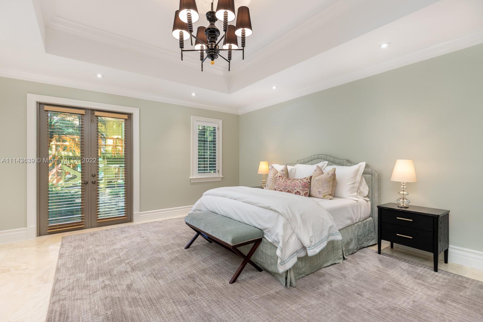 8230 Southwest 53rd Avenue Miami, FL 33143 - Photo 22 of 34 a spacious bedroom with a bed a chandelier and large window