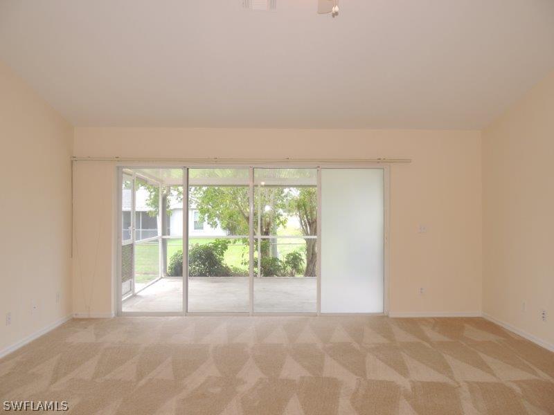 17416 Kentucky Road Fort Myers, FL 33967 - Photo 3 of 13 a view of an empty room with wooden floor and a window