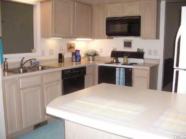 2928 Englefield Drive Raleigh, NC 27615 - Photo 3 of 9 An open kitchen with light, bright counters and cabinetry. A built in microwave and spacious bar top/work area make this kitchen a fun place to prepare and share snacks and meals!