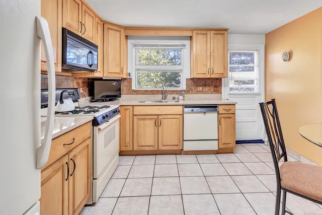 a kitchen with stainless steel appliances granite countertop a stove a sink and a refrigerator