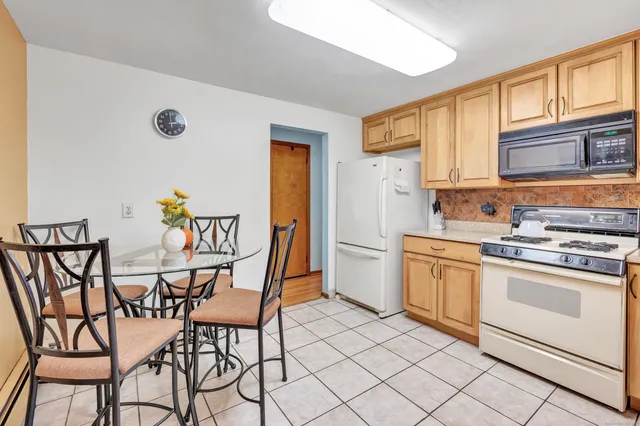 a kitchen with stainless steel appliances a stove a sink cabinets and a dining table