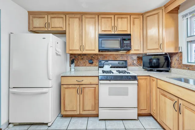 a kitchen with white cabinets and white appliances