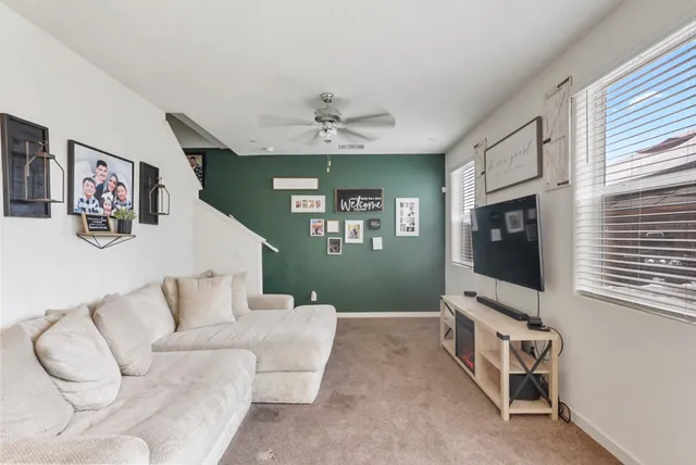 a living room with furniture a flat screen tv and a window