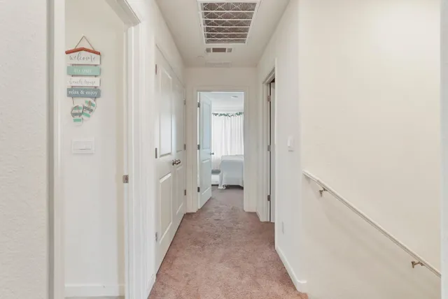 a view of a hallway with white walls and a white door