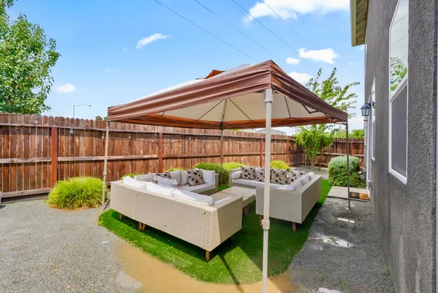 a view of a house with backyard and sitting area