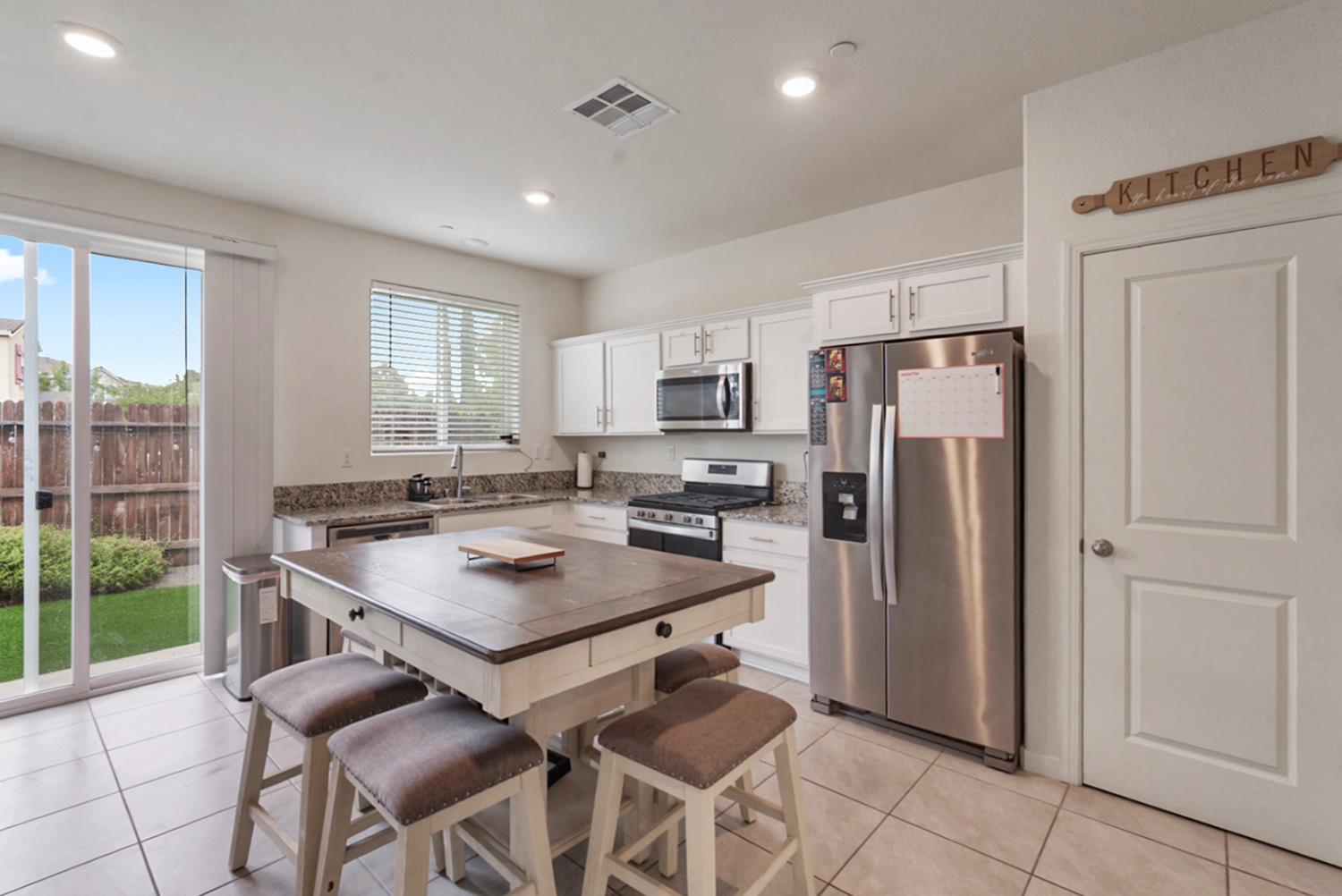 377 Shafer Avenue Merced, CA 95348 - Photo 8 of 36 a kitchen with a refrigerator a table and chairs in it