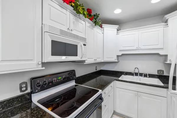 a kitchen with granite countertop a stove and a microwave
