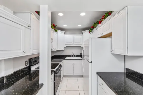 a kitchen that has a lot of cabinets and wooden floor