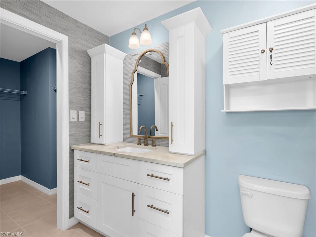 731 Hadley Place West Naples, FL 34104 - Photo 22 of 30 Primary Bathroom With With Renovated White Shaker Cabinets With Vanity Drawers and Cabinet Towers, Quartz Countertop, Added Backsplash, and Wallpaper