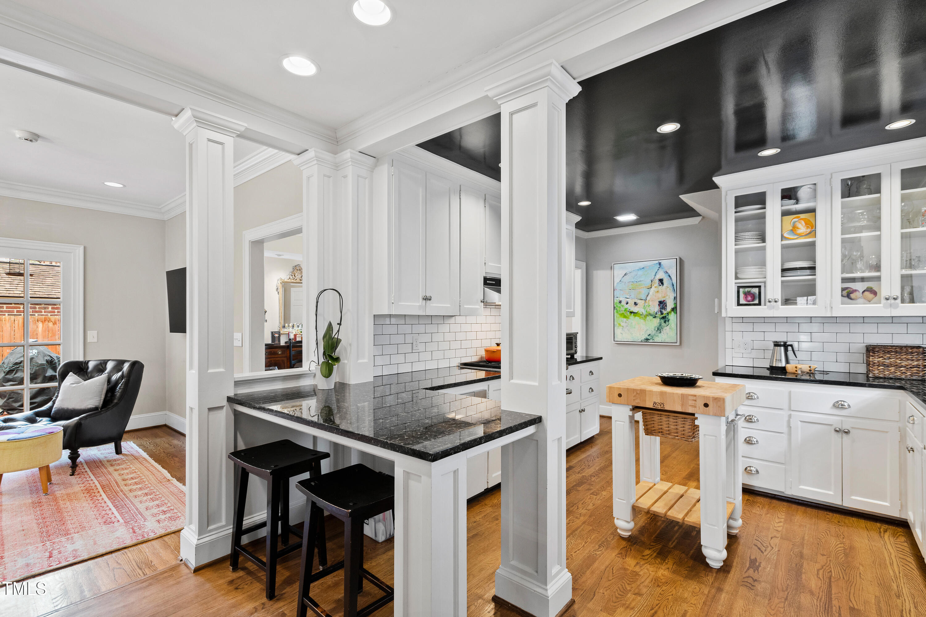 2147 Wake Drive Raleigh, NC 27608 - Photo 17 of 48 a kitchen with stainless steel appliances kitchen island granite countertop a table chairs in it and a wooden floors