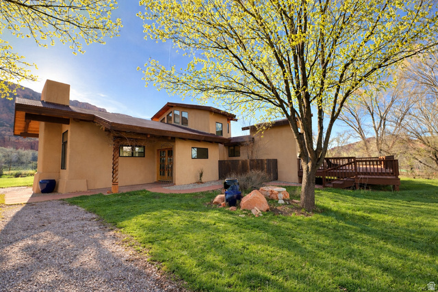 Front entryway of house with a lawn, stucco siding, and a chimney