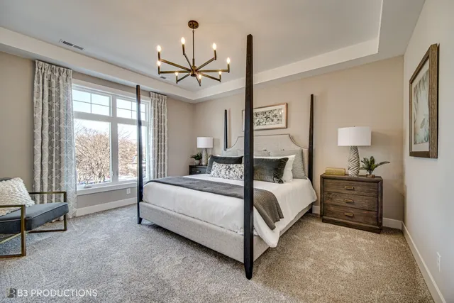 a bedroom with a bed and a chandelier