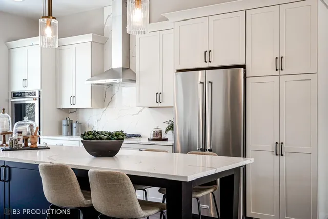 a kitchen with stainless steel appliances granite countertop a stove a refrigerator and a dining table with wooden cabinet