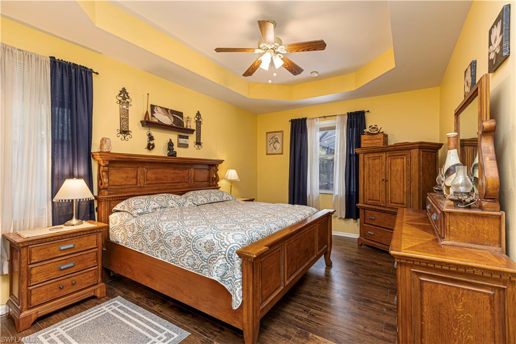 4065 10th Avenue Southeast Naples, FL 34117 - Photo 11 of 32 a bedroom with a bed and wooden floor