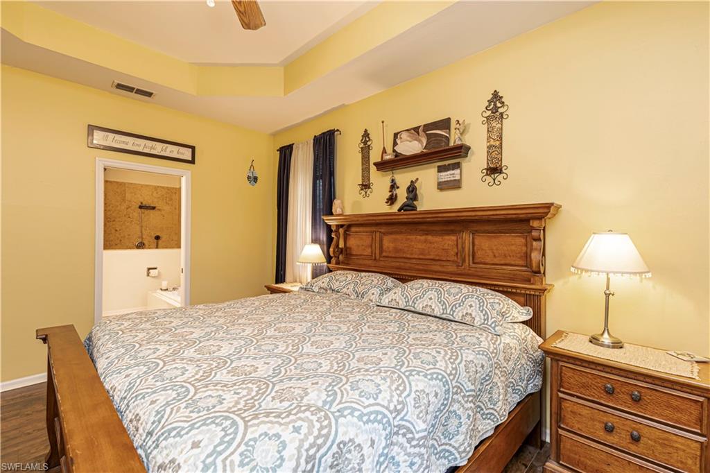 4065 10th Avenue Southeast Naples, FL 34117 - Photo 12 of 32 a bedroom with a bed and cabinets