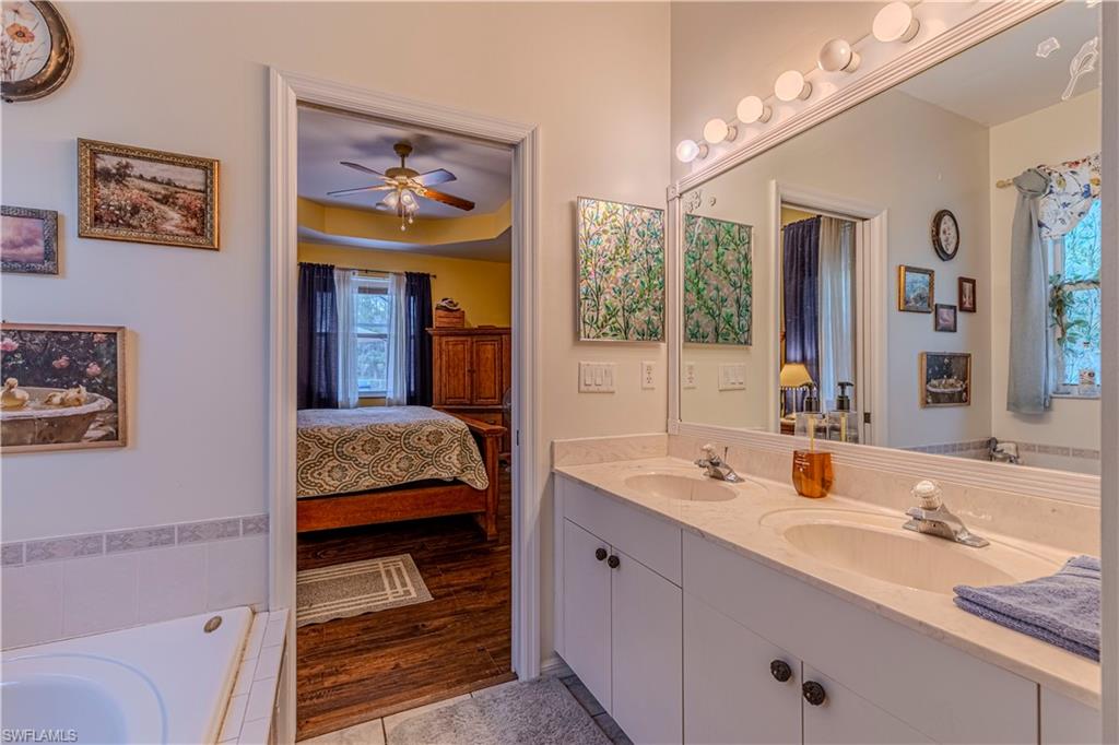 4065 10th Avenue Southeast Naples, FL 34117 - Photo 17 of 32 a en suite bathroom with a sink double vanity and a large mirror
