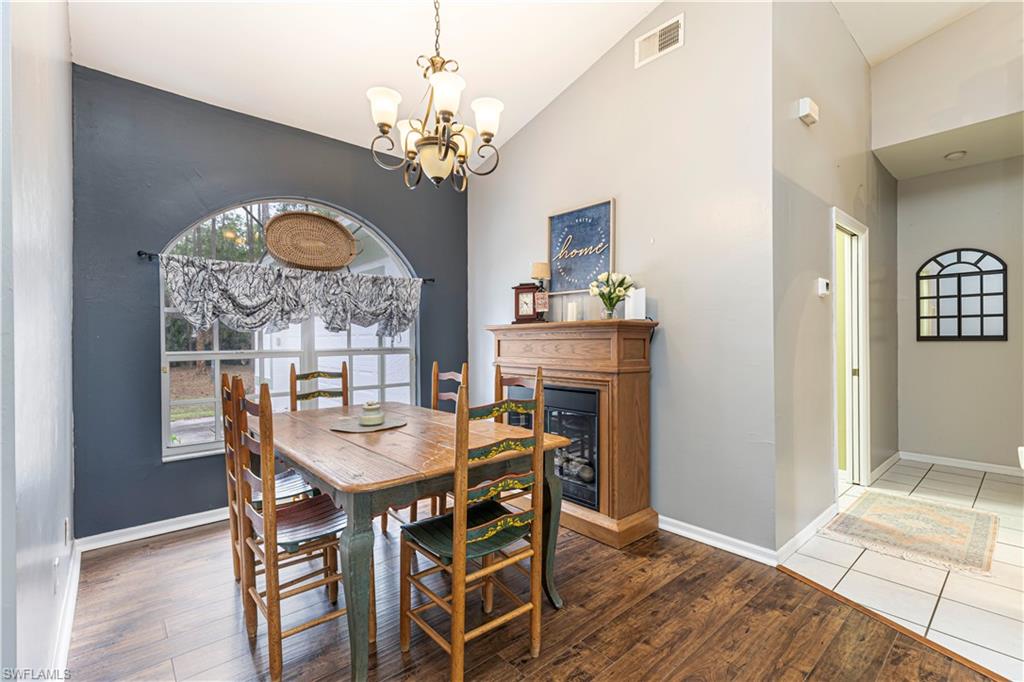 4065 10th Avenue Southeast Naples, FL 34117 - Photo 7 of 32 a view of a dining room with furniture a chandelier and wooden floor