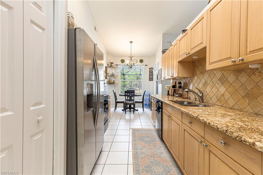 4065 10th Avenue Southeast Naples, FL 34117 - Photo 9 of 32 a kitchen with stainless steel appliances granite countertop a stove oven and a refrigerator with cabinets