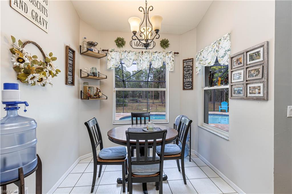 4065 10th Avenue Southeast Naples, FL 34117 - Photo 10 of 32 a view of a dining room with furniture and chandelier