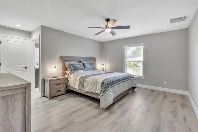 a bedroom with a large bed and a chandelier