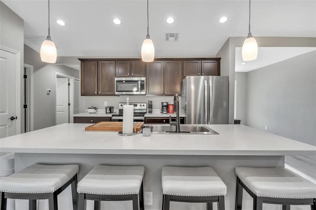 6193 Cabal Lane Port Charlotte, FL 33981 - Photo 24 of 28 a kitchen with cabinets a sink stainless steel appliances and couches