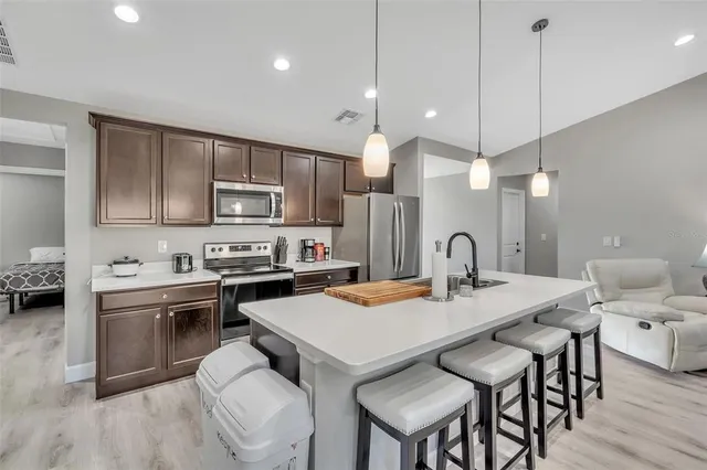 a kitchen with a dining table chairs sink and cabinets