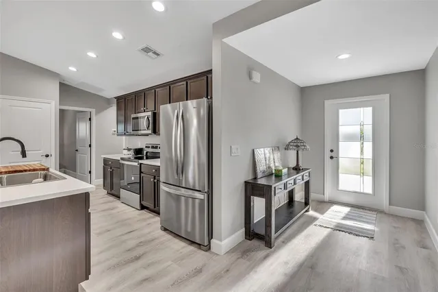 a kitchen with granite countertop a refrigerator and a stove top oven