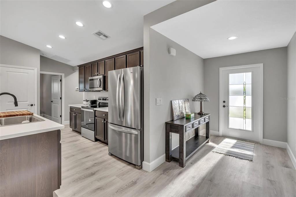 6193 Cabal Lane Port Charlotte, FL 33981 - Photo 6 of 28 a kitchen with granite countertop a refrigerator and a stove top oven