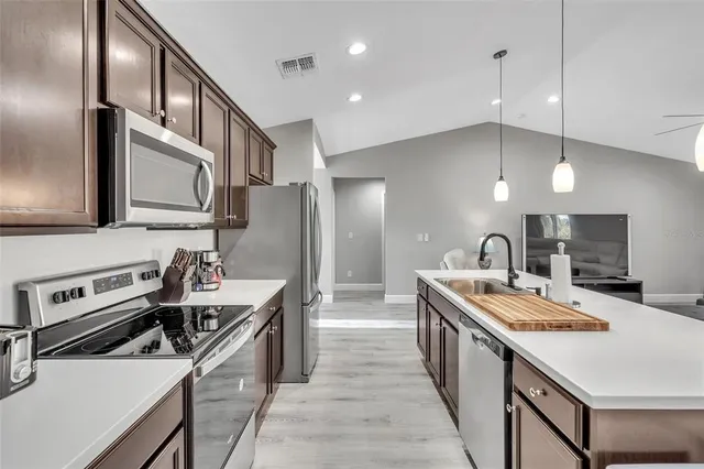 a kitchen with stainless steel appliances granite countertop a sink stove and refrigerator