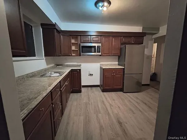 a kitchen with stainless steel appliances granite countertop a refrigerator and a stove top oven