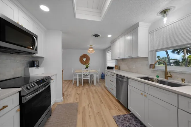 a kitchen with a sink stainless steel appliances and cabinets