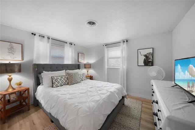 a bedroom with a bed and wooden floor