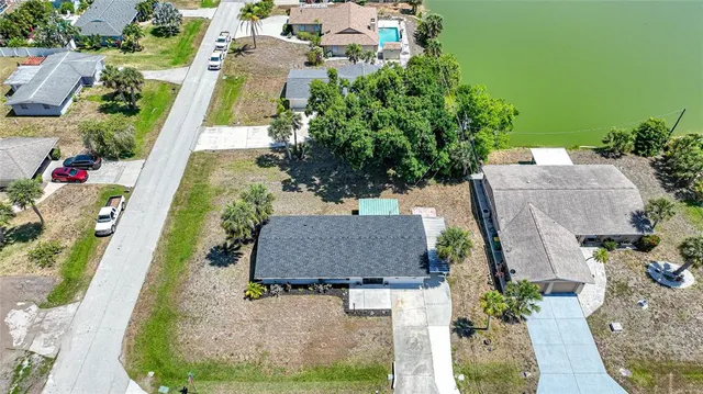 an aerial view of residential houses with outdoor space and lake view