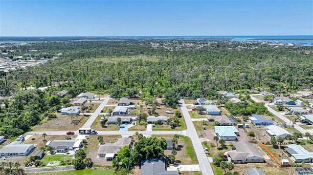 an aerial view of residential houses with outdoor space and trees