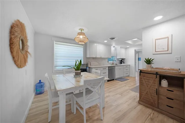 a kitchen with granite countertop white cabinets and stainless steel appliances