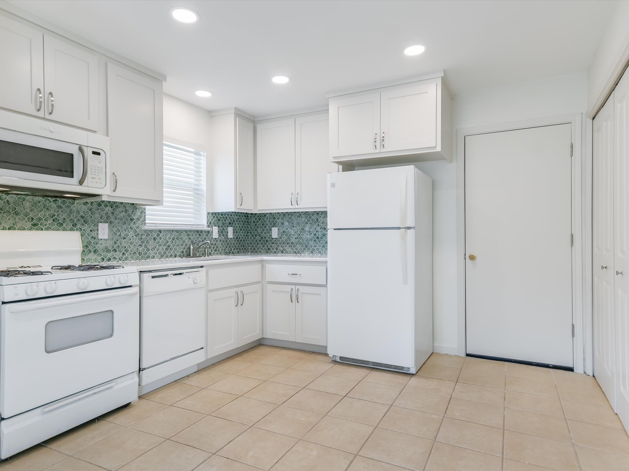 5104 Delores Avenue, Unit B Austin, TX 78721 - Photo 5 of 12 a kitchen with white cabinets and white appliances