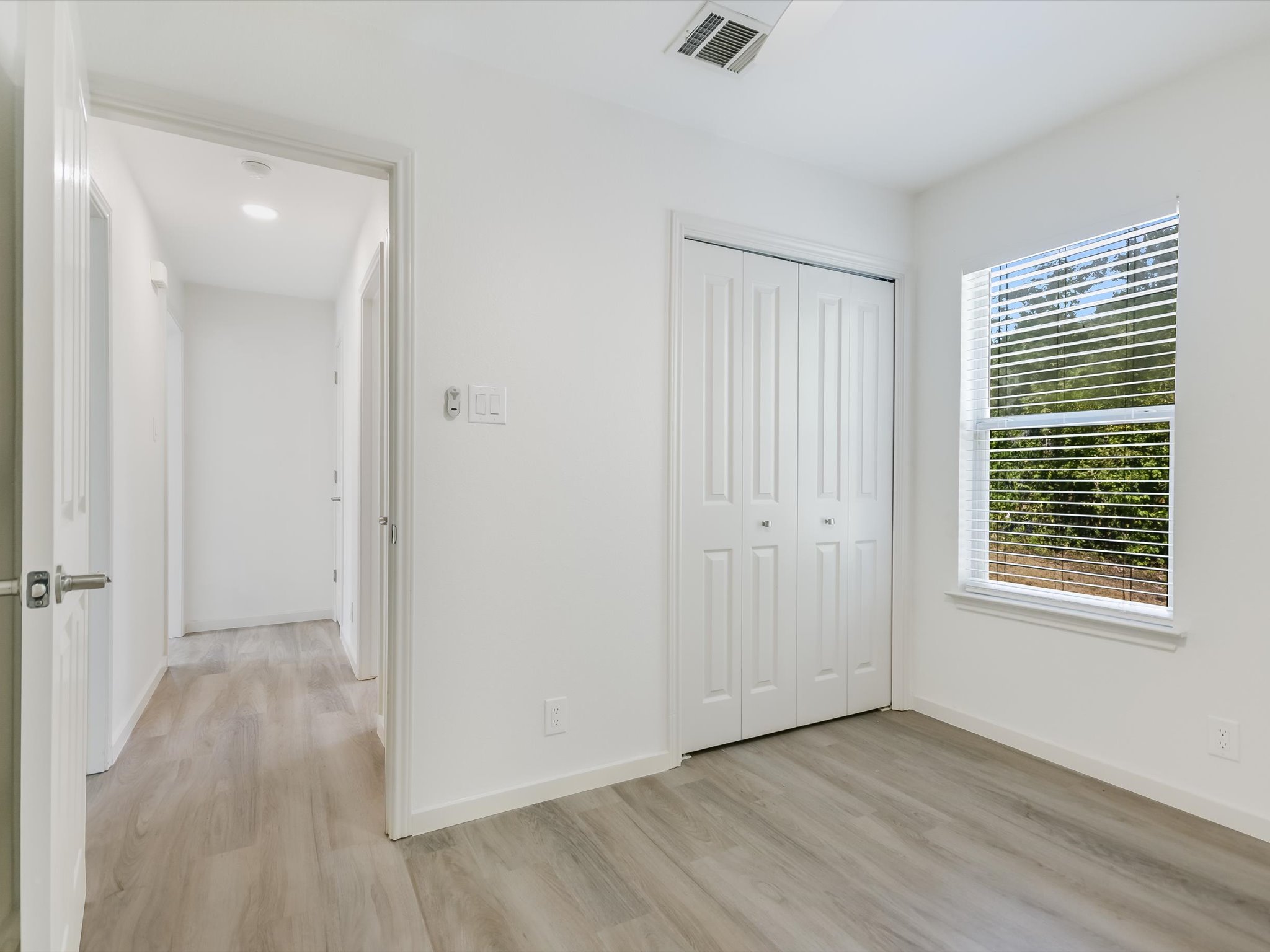 5104 Delores Avenue, Unit B Austin, TX 78721 - Photo 9 of 12 an empty room with wooden floor and windows