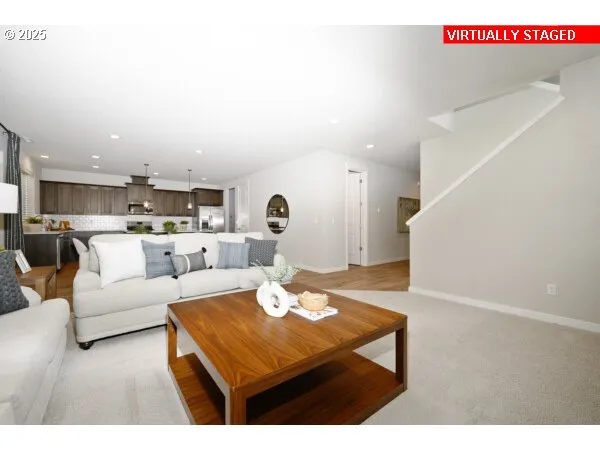 a living room with furniture and view of kitchen