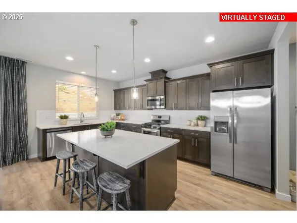 a kitchen with kitchen island a sink counter space and stainless steel appliances