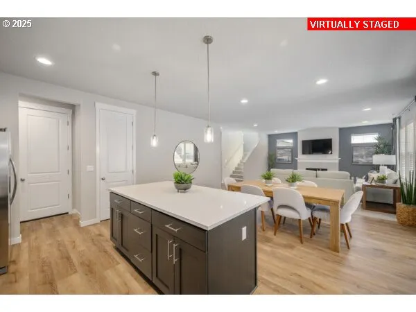 a view of a dining room and livingroom with furniture wooden floor a rug a painting and a chandelier