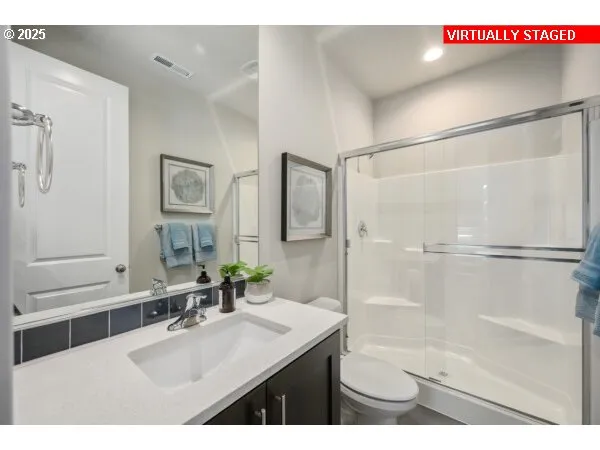 a bathroom with a sink a toilet a mirror and shower