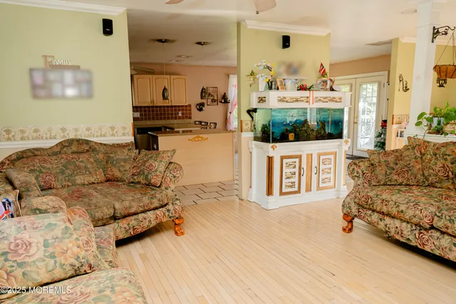 a kitchen with stainless steel appliances kitchen island granite countertop a refrigerator a sink dishwasher and white cabinets with wooden floor