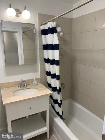 a bathroom with a bathtub a sink a shower and a mirror