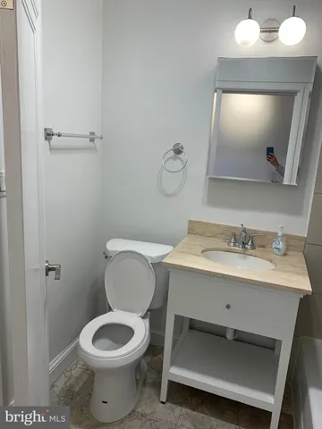 a bathroom with a toilet sink and mirror
