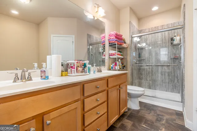 a bathroom with a sink vanity mirror and toilet