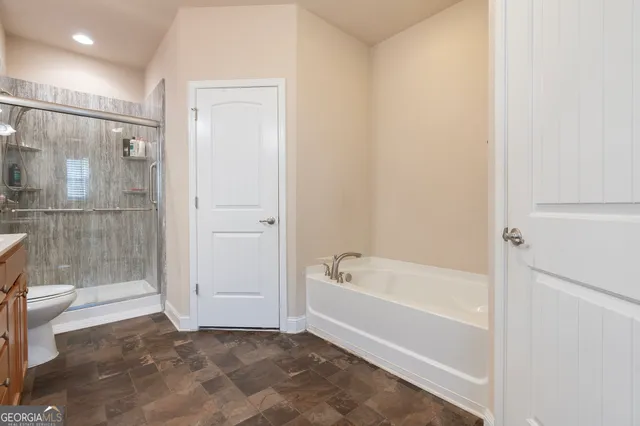 a bathroom with a tub a toilet and a shower