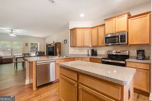 a kitchen with stainless steel appliances granite countertop a stove a sink and a microwave