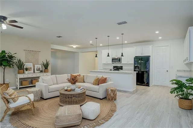 a living room with furniture and a dining table with kitchen view