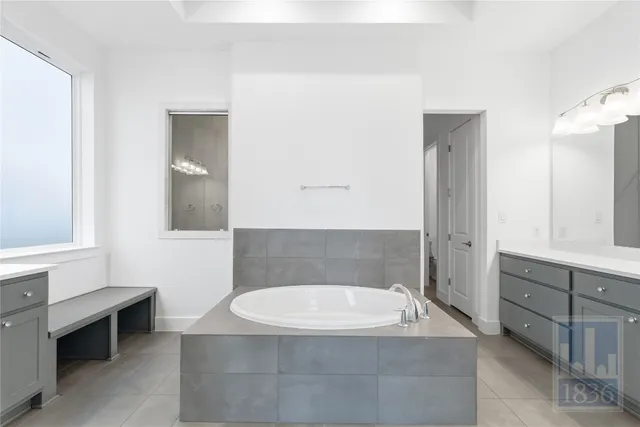 a bathroom with a granite countertop bathtub sink and mirror