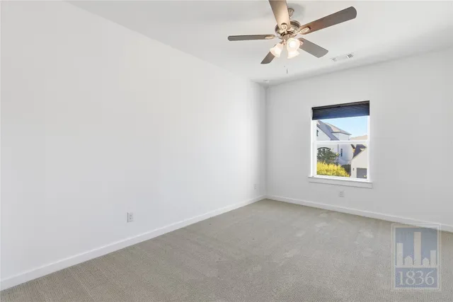 an empty room with a window and a ceiling fan
